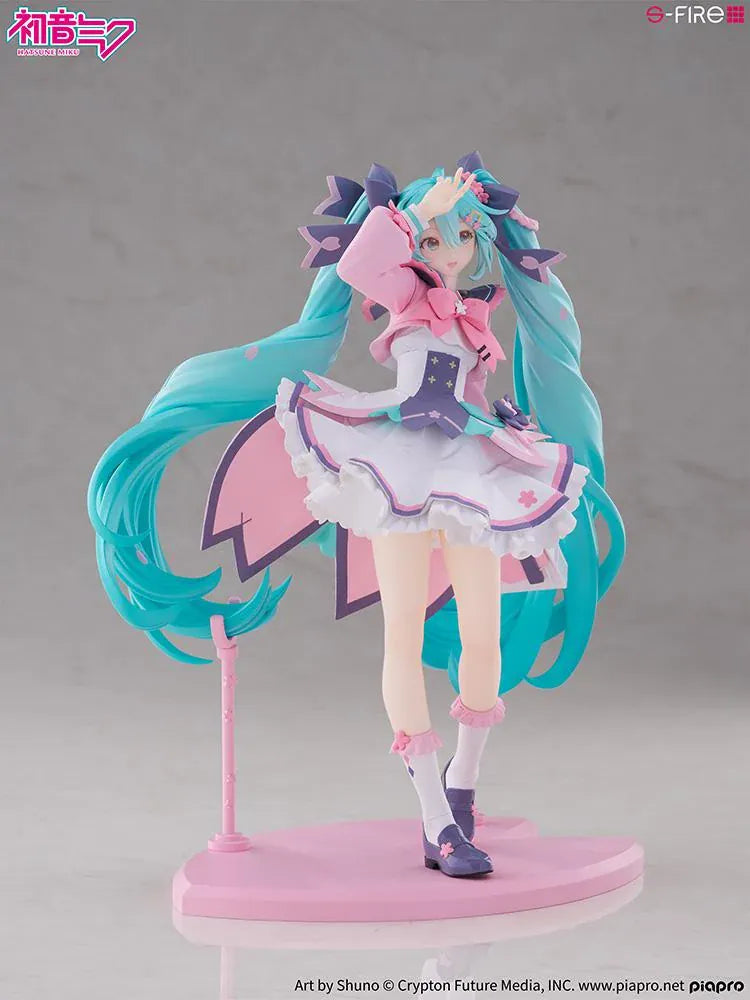 Hatsune Miku New School Term figure with turquoise twin-tails, a pink and white ruffled outfit, purple bows, and flower accents on a pink base.