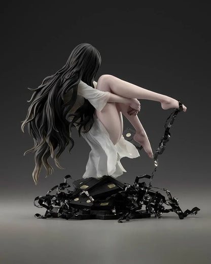 Sadako BISHOUJO Sadako 1/7 Scale Figure (Rerelease) featuring a long black-haired horror character wearing a flowing white dress, seated above a pile of VHS tapes with tangled black film ribbons.