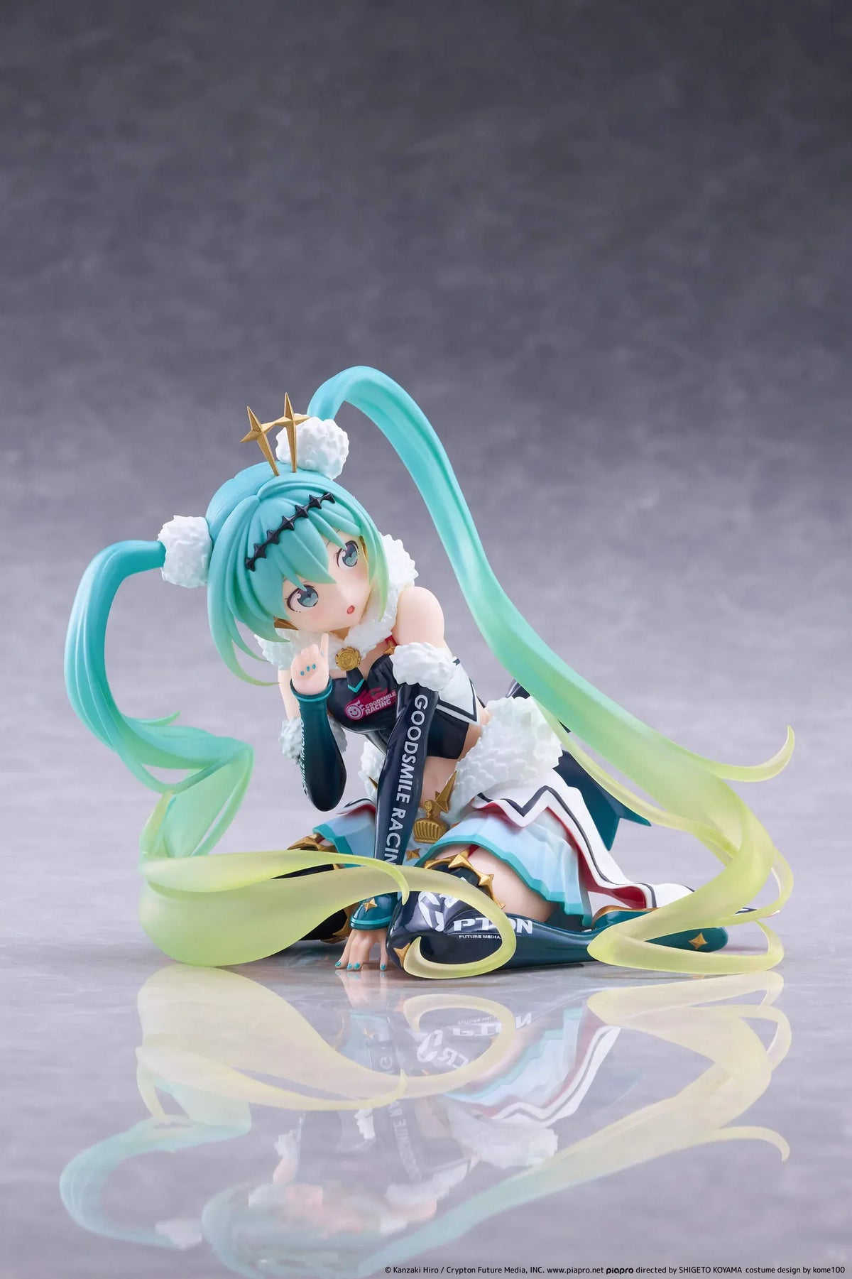Racing Miku 2018 Ver. Round 8 figure seated in a white, black, and turquoise racing outfit with long gradient twin tails.