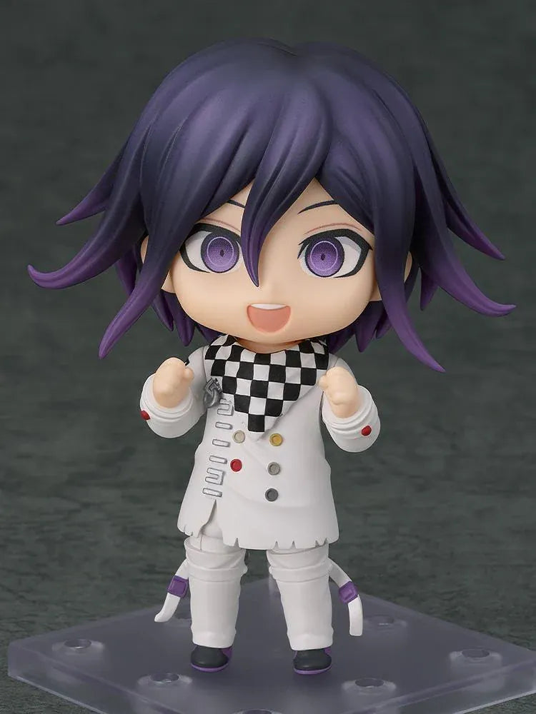 Nendoroid Kokichi Oma with purple hair, violet eyes, a black peaked cap and cape, and a white outfit, smiling with both arms extended.