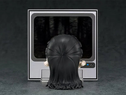 Nendoroid Sadako figure with long black hair covering her face, wearing a white dress and standing barefoot on a clear display base.