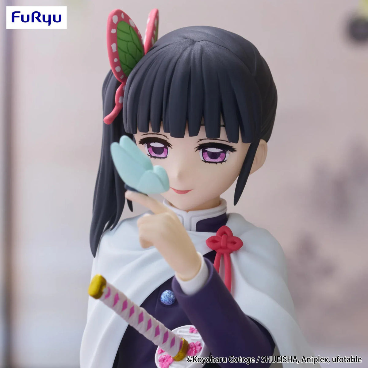 Kanao Tsuyuri Noodle Stopper figure seated in her Demon Slayer uniform and white cape while holding a blue butterfly.