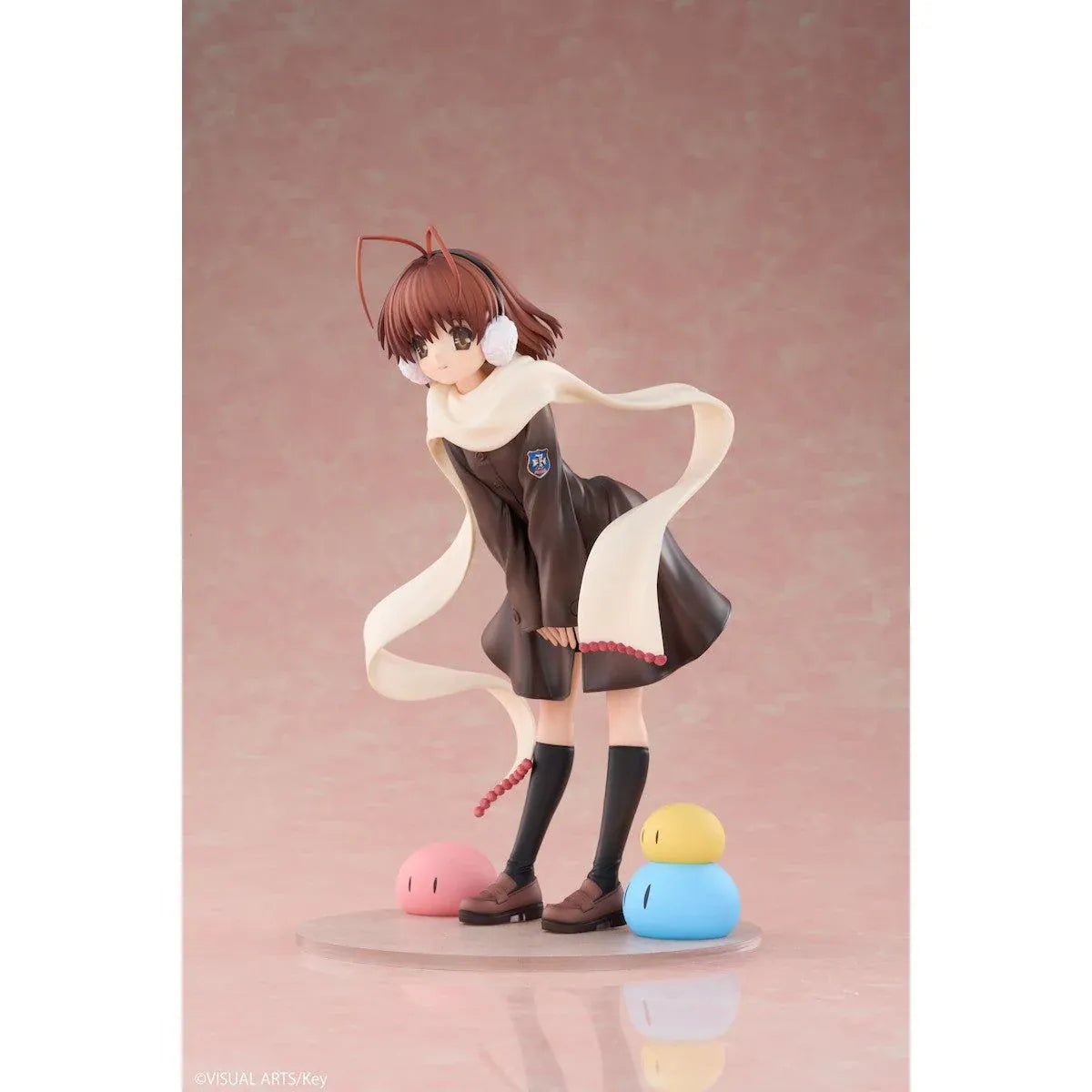CLANNAD Nagisa Furukawa 1/6 Scale Figure featuring a smiling brown-haired anime girl wearing a dark school uniform, cream-colored scarf, white earmuffs, and black knee-high socks, surrounded by colorful Dango Daikazoku characters.