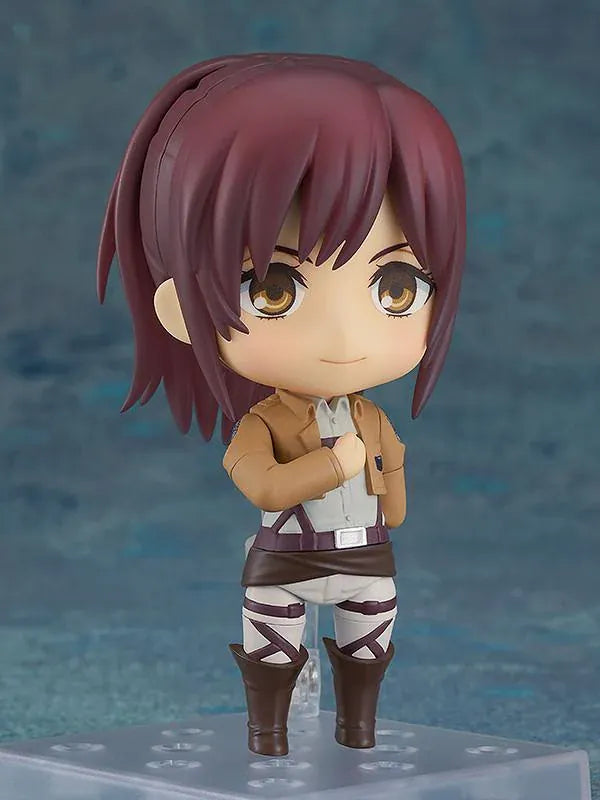 Attack on Titan Nendoroid Sasha Braus rerelease figure wearing her Survey Corps uniform and green cloak with dual blades and maneuvering gear.