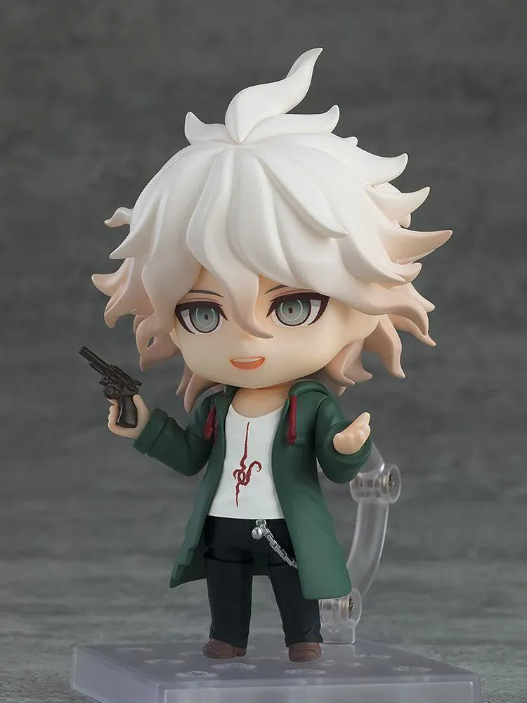 Nendoroid Nagito Komaeda with tousled white hair, pale green eyes, a green coat, white printed shirt, and black trousers, extending one hand.