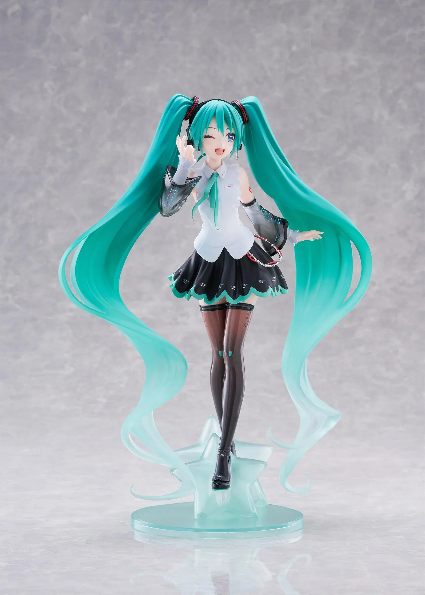 Vocaloid T-Most Hatsune Miku NT Ver. Figure featuring Miku with long teal twin tails, headphones, black-and-white outfit, wink expression, peace-sign pose, and star-themed base.