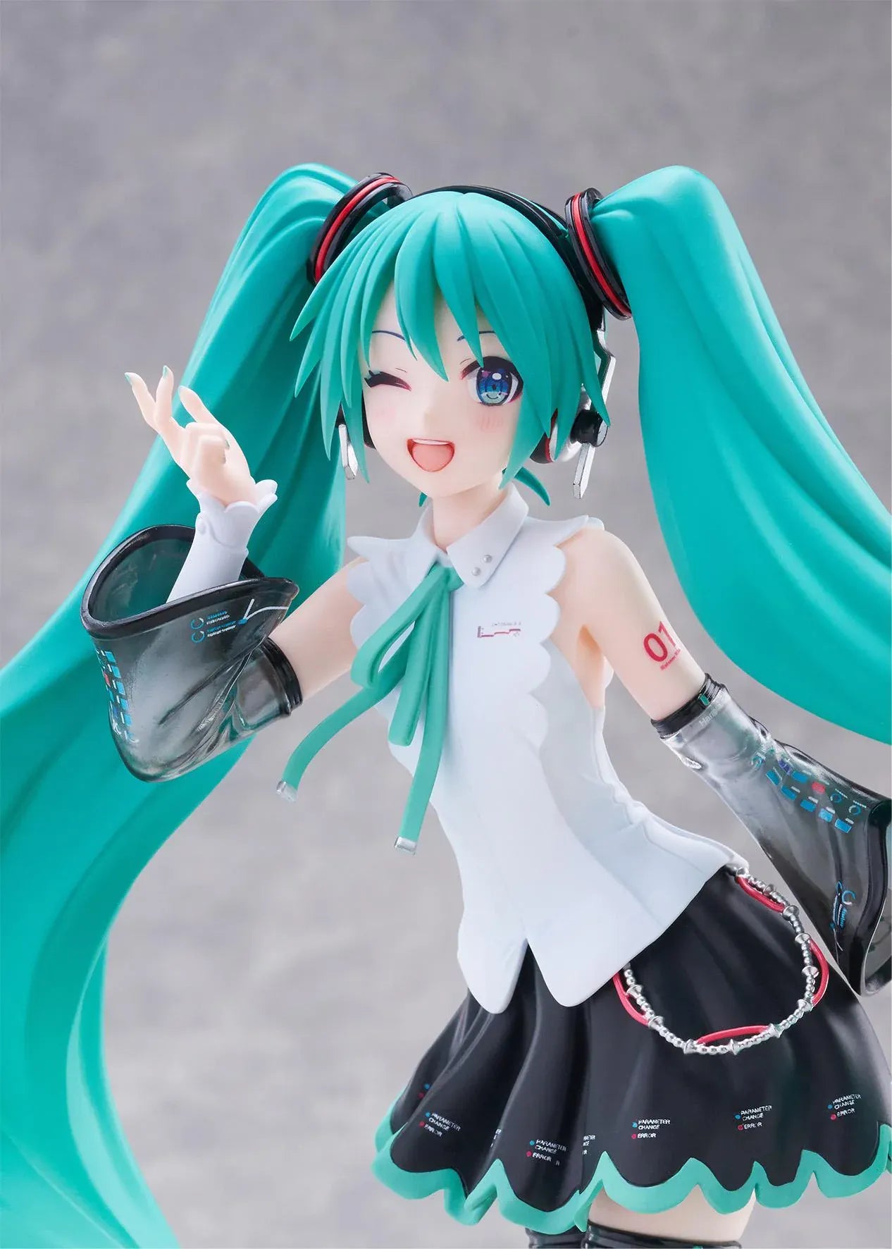 Vocaloid T-Most Hatsune Miku NT Ver. Figure featuring Miku with long teal twin tails, headphones, black-and-white outfit, wink expression, peace-sign pose, and star-themed base.