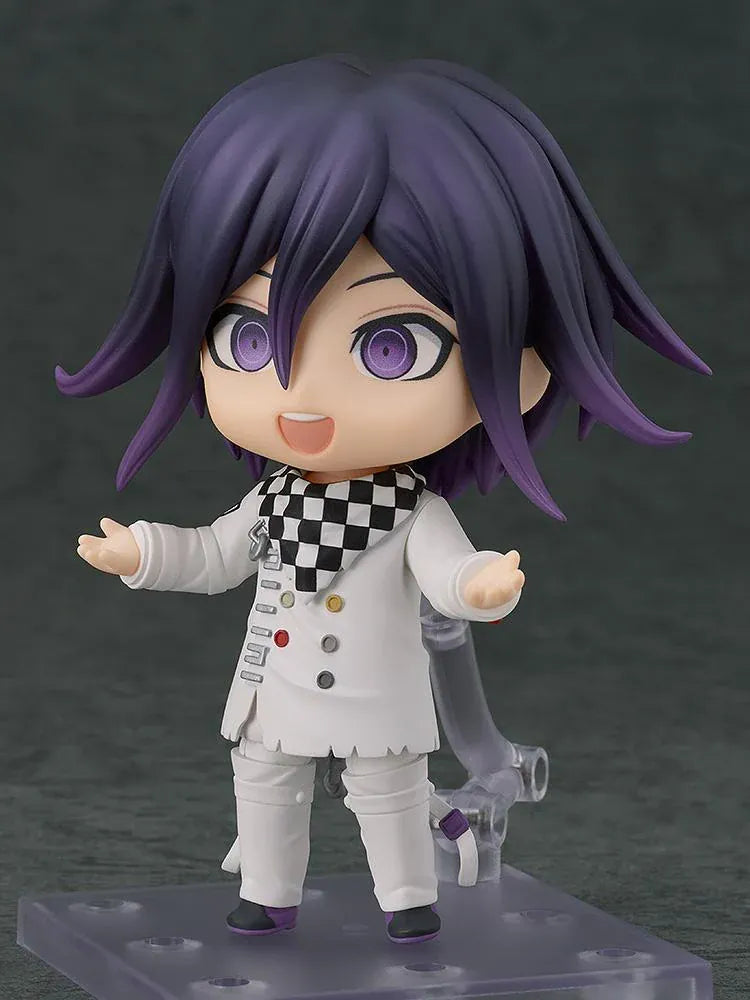 Nendoroid Kokichi Oma with purple hair, violet eyes, a black peaked cap and cape, and a white outfit, smiling with both arms extended.