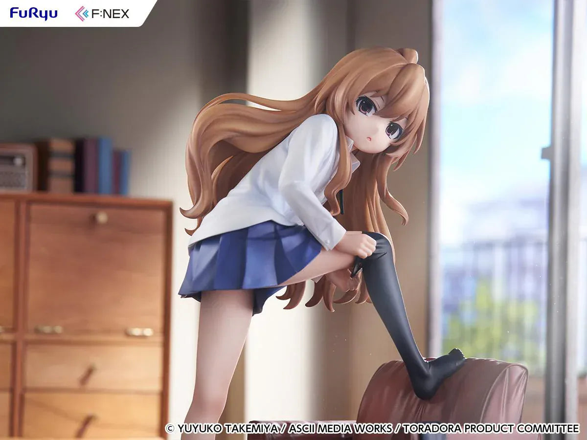 1/7 scale Toradora figure of Taiga Aisaka at home, barefoot and leaning on a leather armchair while pulling on a black thigh-high sock, wearing her school shirt and blue skirt.