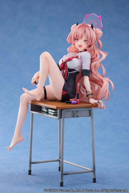 Blue Archive Kirara figure with long pink hair, black horns, and a pink halo, seated on a classroom desk beside nail polish bottles.