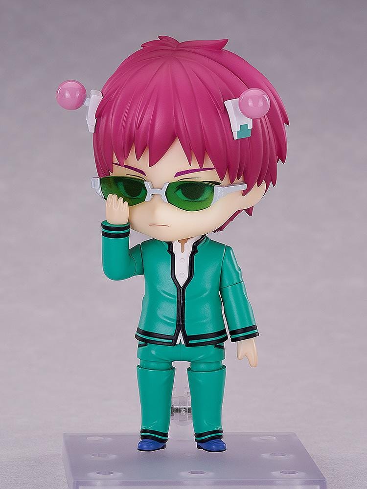 Kusuo Saiki Nendoroid with pink hair, pink-tipped head accessories, green glasses, and a teal school uniform, posed with one hand extended.