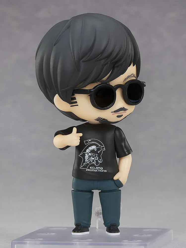 Kojima Productions Nendoroid Hideo Kojima Figure with glasses, black Kojima Productions shirt, and thumbs-up pose
