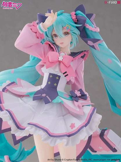 Hatsune Miku New School Term figure with turquoise twin-tails, a pink and white ruffled outfit, purple bows, and flower accents on a pink base.