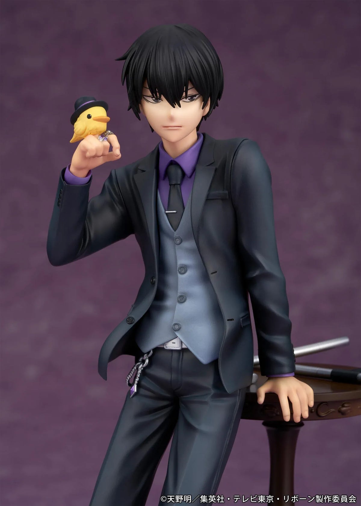 REBORN! Kyoya Hibari Scale Figure featuring a black-haired anime character wearing a black suit, purple shirt, gray vest, and tie, leaning against a wooden table with tonfa weapons while holding his yellow bird companion Hibird.