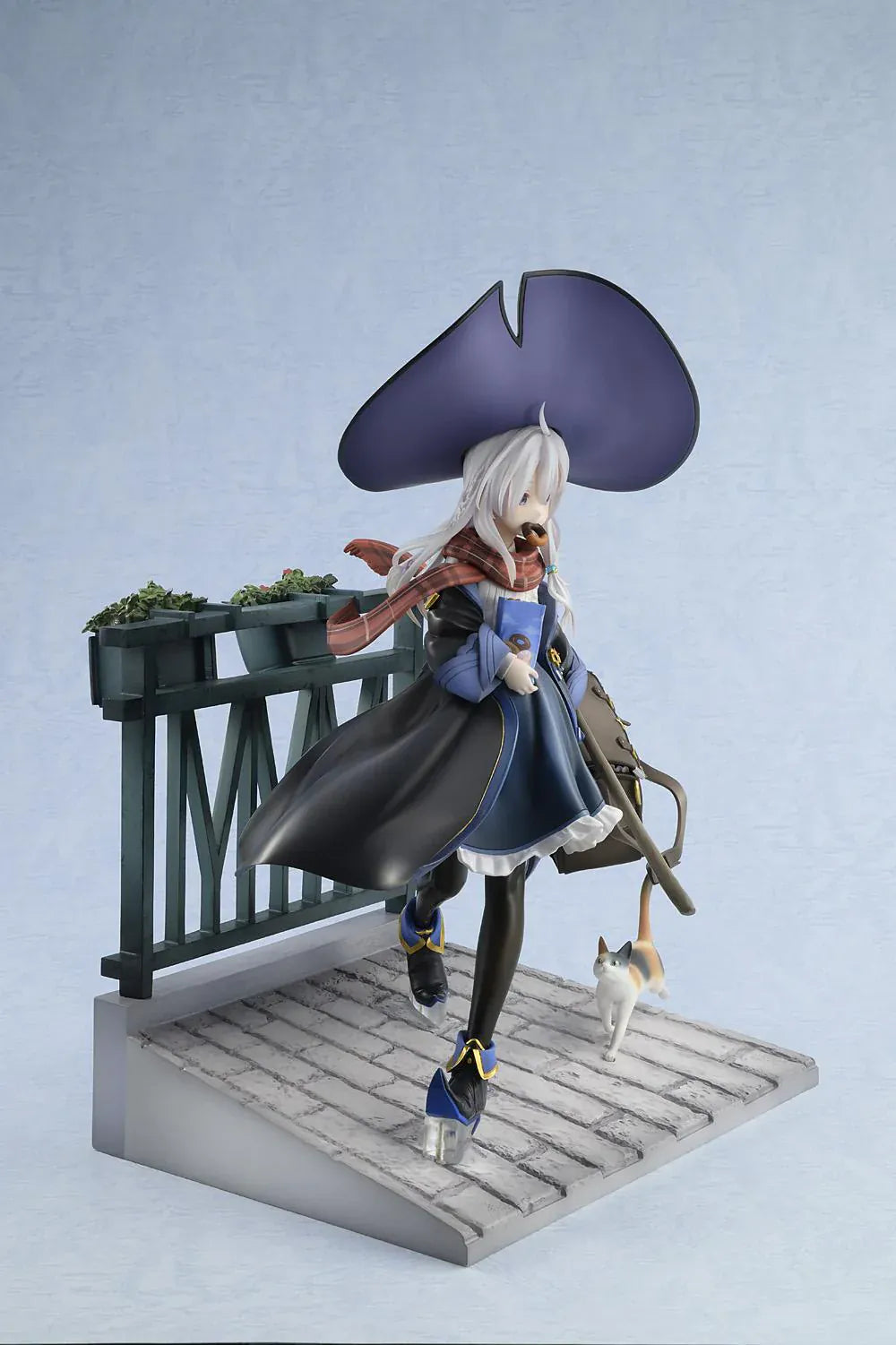 Wandering Witch The Journey of Elaina Elaina DX Ver. 1/7 Scale Figure Rerelease featuring Elaina seated on a bench with witch hat, broom, travel bag, cat, and stone-pavement display base.