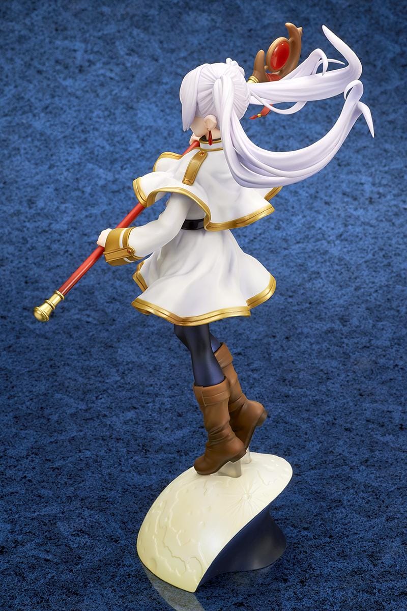Frieren vs Aura 1/7 scale figure holding a red staff while wearing her white-and-gold mage outfit on a rounded display base.