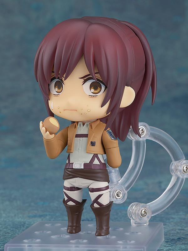 Attack on Titan Nendoroid Sasha Braus rerelease figure wearing her Survey Corps uniform and green cloak with dual blades and maneuvering gear.