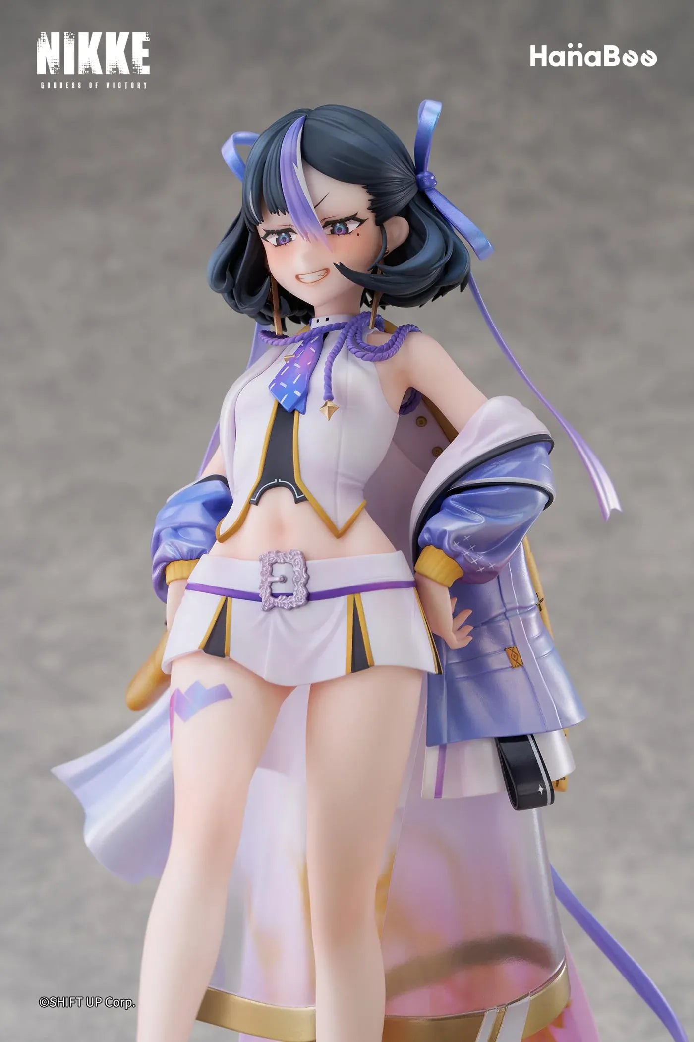 Goddess of Victory Nikke Syuen Deluxe Edition 1/6 Scale Figure featuring Syuen in a white-and-purple outfit with ribbon details, themed base, chibi mascot accent, can badge, and acrylic-style bonus artwork.