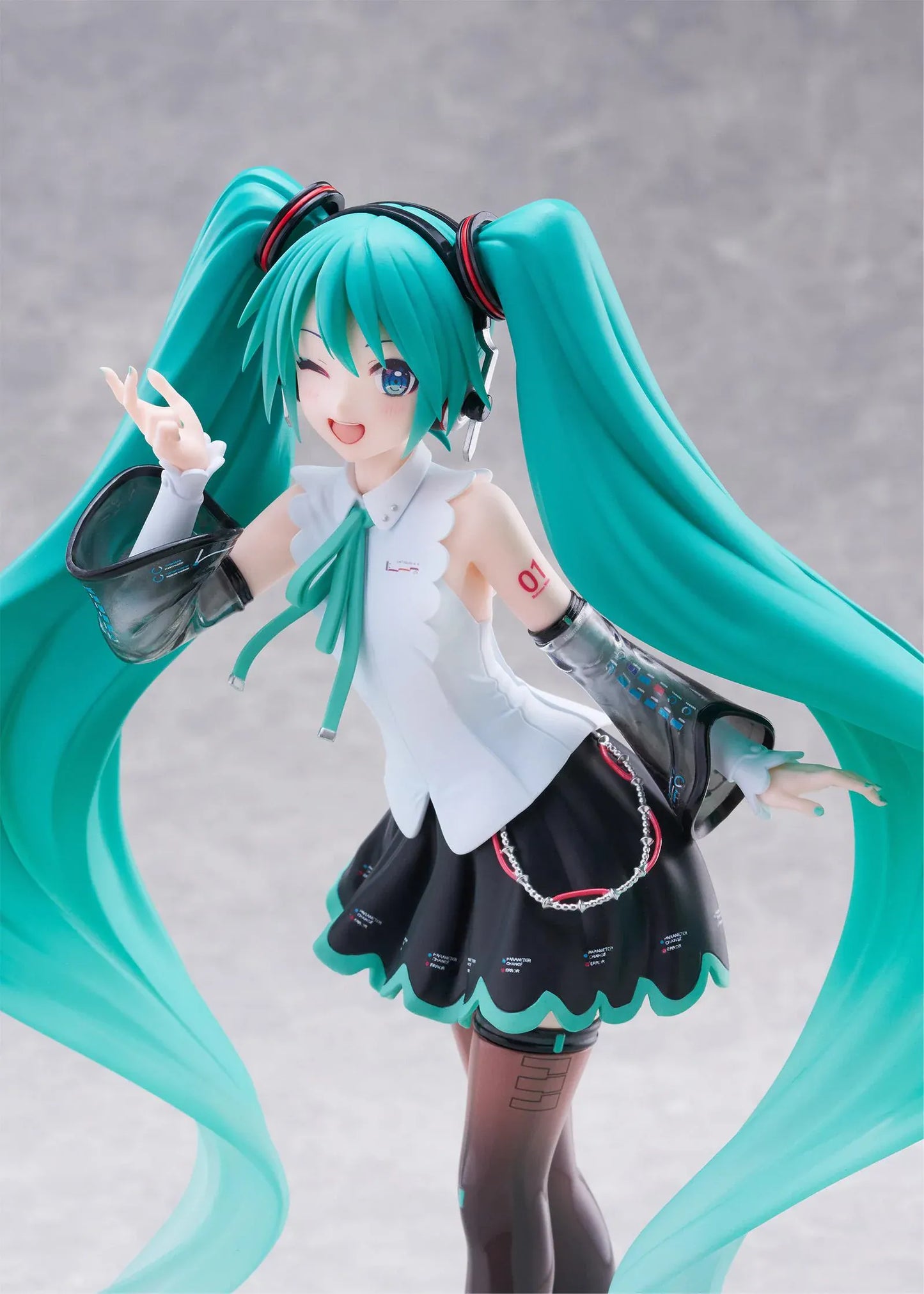 Vocaloid T-Most Hatsune Miku NT Ver. Figure featuring Miku with long teal twin tails, headphones, black-and-white outfit, wink expression, peace-sign pose, and star-themed base.