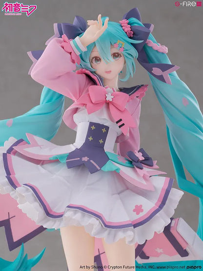 Hatsune Miku New School Term figure with turquoise twin-tails, a pink and white ruffled outfit, purple bows, and flower accents on a pink base.