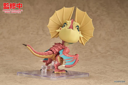 Monster Hunter Nendoroid Yian Kut-Ku with yellow ear fans, an open beak, pink-red scales, and spread wings with turquoise membranes.