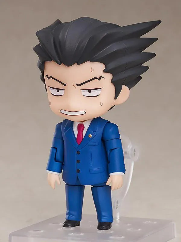 Ace Attorney Phoenix Wright Nendoroid rerelease figure wearing a blue suit and pointing beside a Japanese Objection effect part.