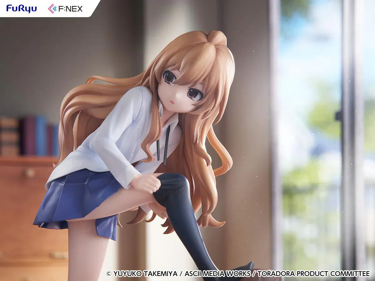 1/7 scale Toradora figure of Taiga Aisaka at home, barefoot and leaning on a leather armchair while pulling on a black thigh-high sock, wearing her school shirt and blue skirt.