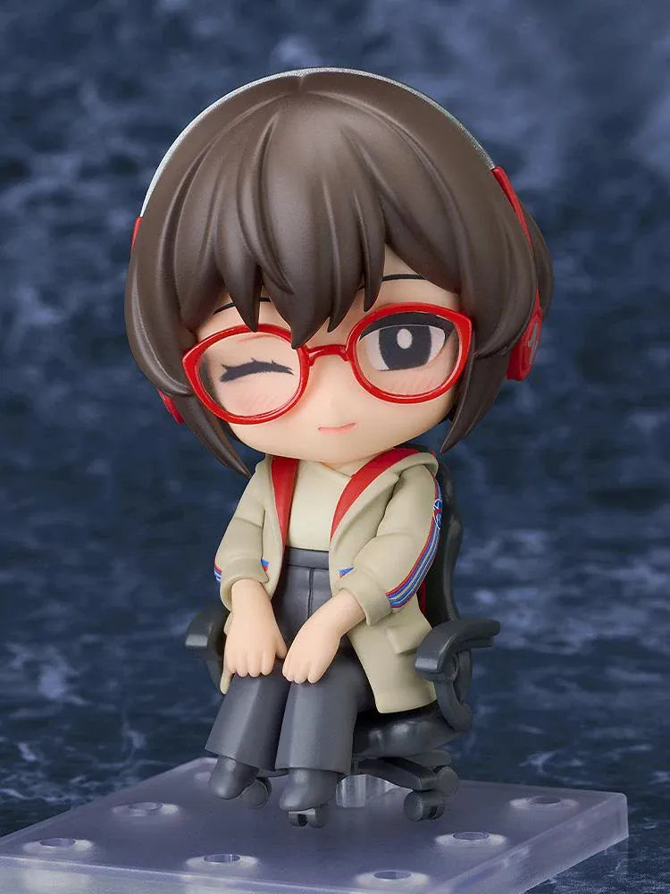 Nendoroid Satone figure seated in a black office chair, wearing red glasses, red headphones, a beige jacket, and dark gray trousers.