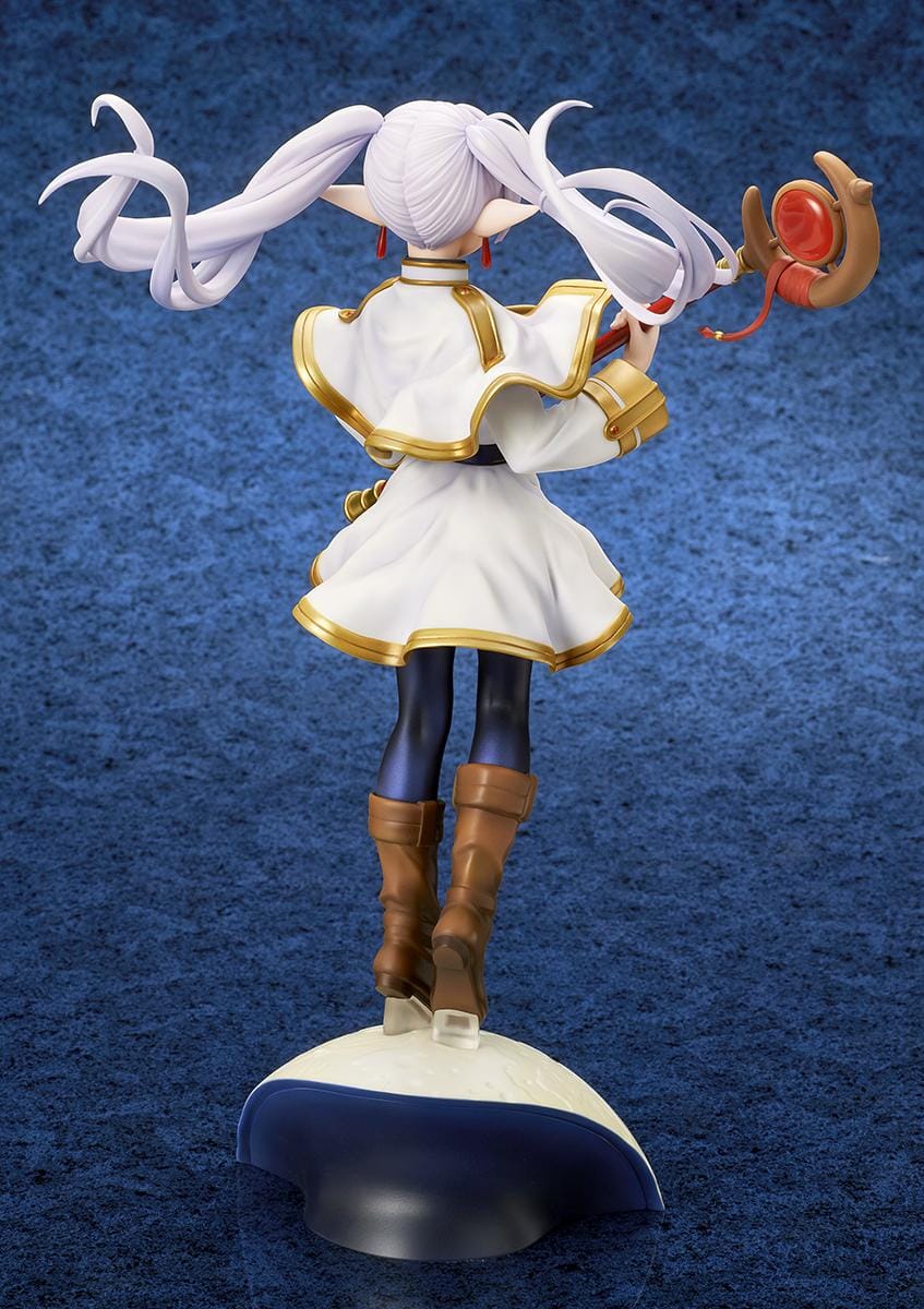 Frieren vs Aura 1/7 scale figure holding a red staff while wearing her white-and-gold mage outfit on a rounded display base.