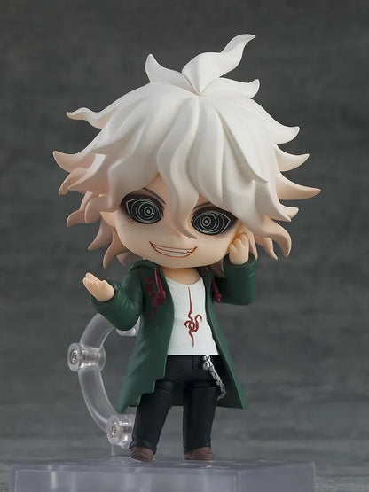 Nendoroid Nagito Komaeda with tousled white hair, pale green eyes, a green coat, white printed shirt, and black trousers, extending one hand.