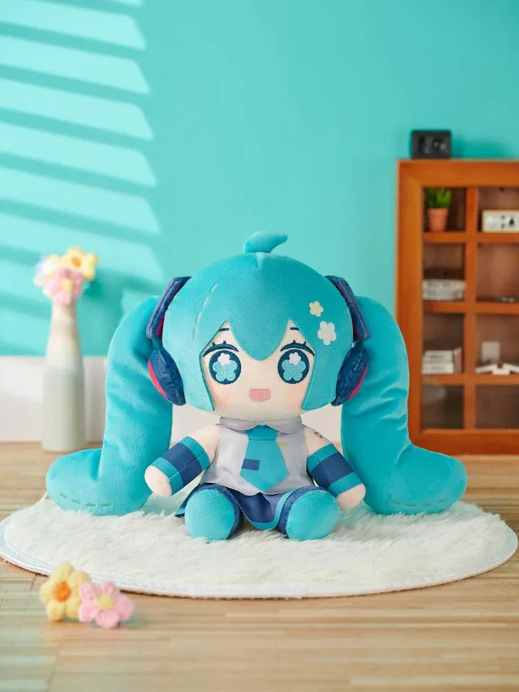 Hatsune Miku Huggy Doll plushie with turquoise twin tails, flower-shaped embroidered eyes, and her signature outfit.