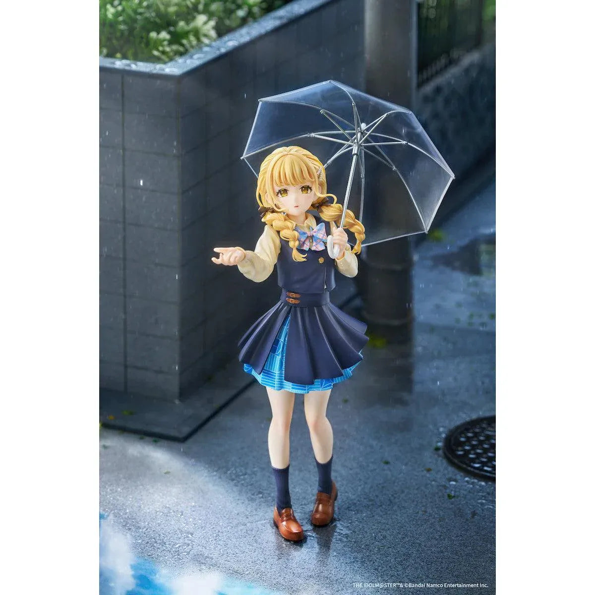 Gakuen iDOLM@STER Kotone Fujita Ameagari no Iris Before Special Training Ver. 1/7 Scale Figure featuring a blonde-haired anime girl with twin braids wearing a navy-blue school uniform and holding a transparent umbrella on a yellow display base.