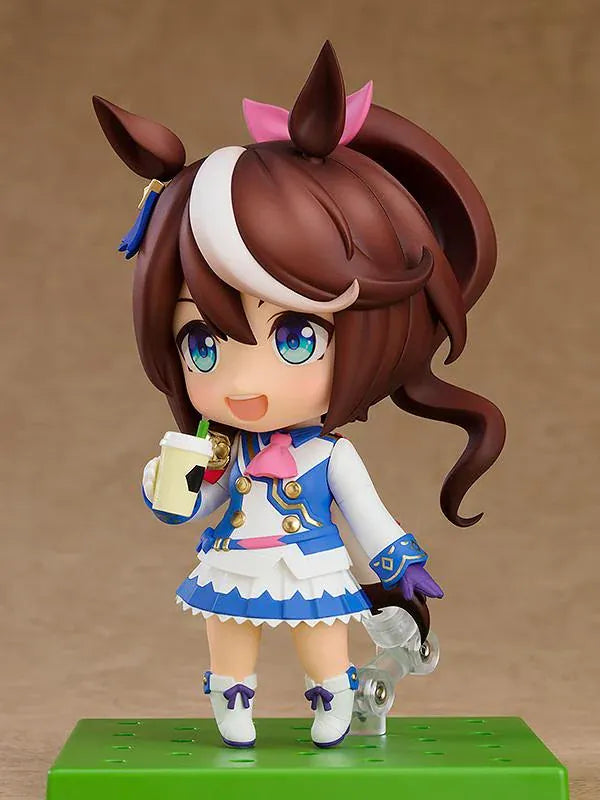 Umamusume Pretty Derby Nendoroid Tokai Teio rerelease figure with brown hair, a white forelock, pink bow, and blue-and-white racing uniform.