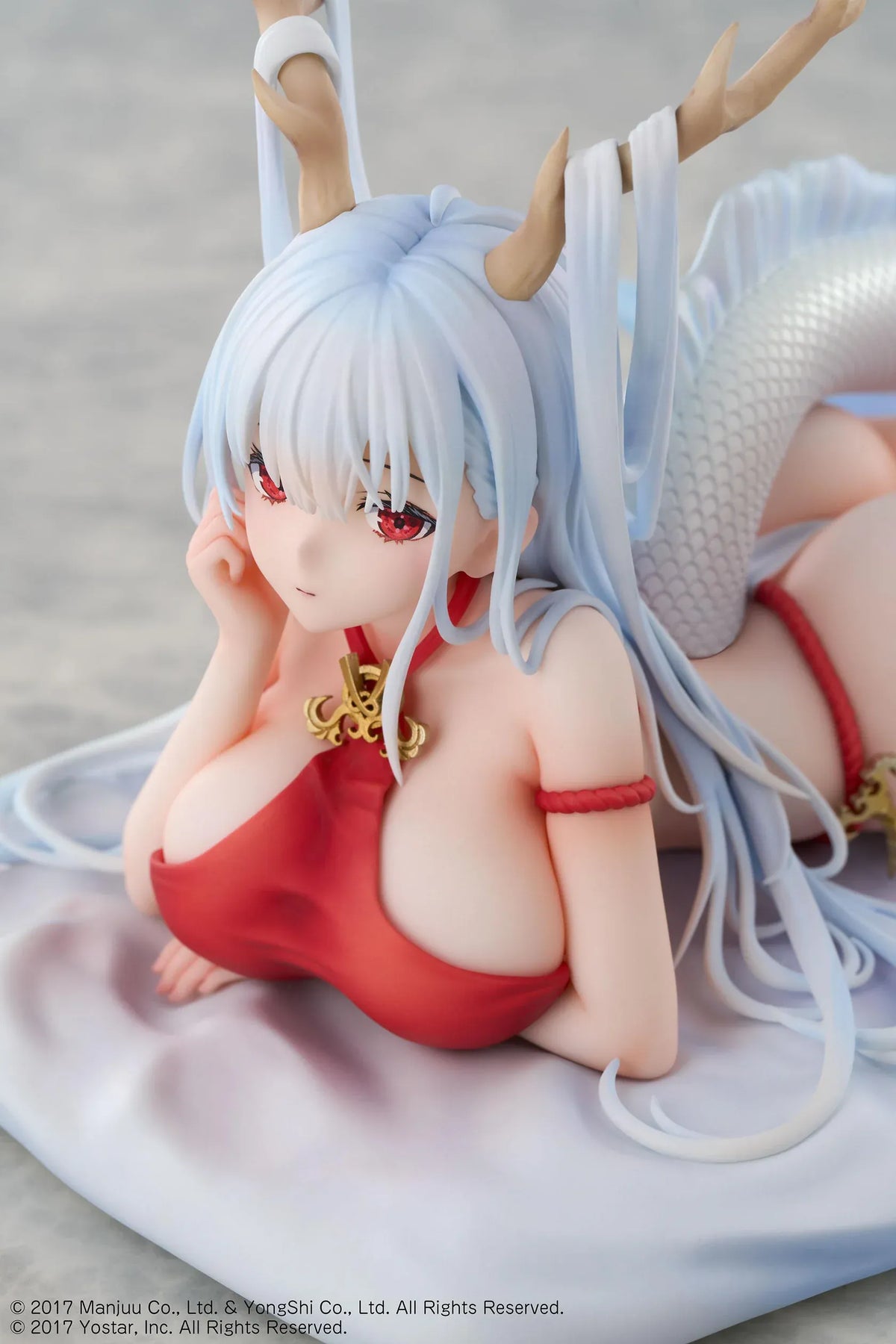Azur Lane Shimanto 1/7 scale figure reclining on a pale cushion with icy-blue hair, branching horns, a red outfit, and a curling dragon tail.