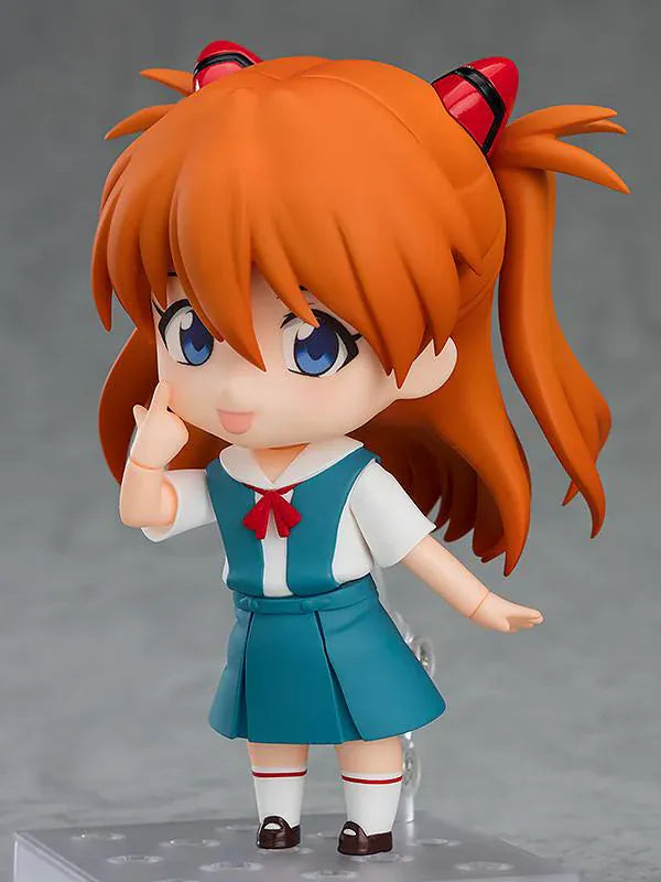 Rebuild of Evangelion Nendoroid Asuka Shikinami Langley Figure Rerelease featuring Asuka with orange twin tails, blue eyes, school uniform, and cheerful waving pose.