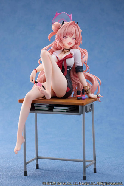 Blue Archive Kirara figure with long pink hair, black horns, and a pink halo, seated on a classroom desk beside nail polish bottles.