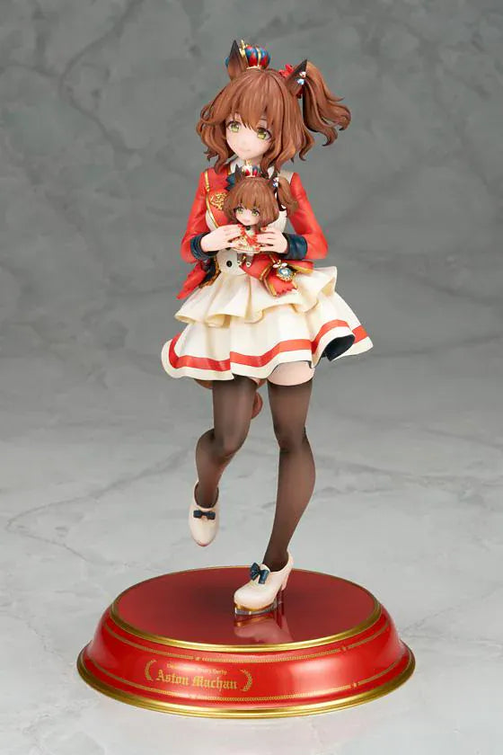 UmaMusume Pretty Derby Aston Machan 1/7 Scale Figure featuring Aston Machan with horse ears, short brown hair, red-and-cream outfit, plush doll accessory, and themed display base.