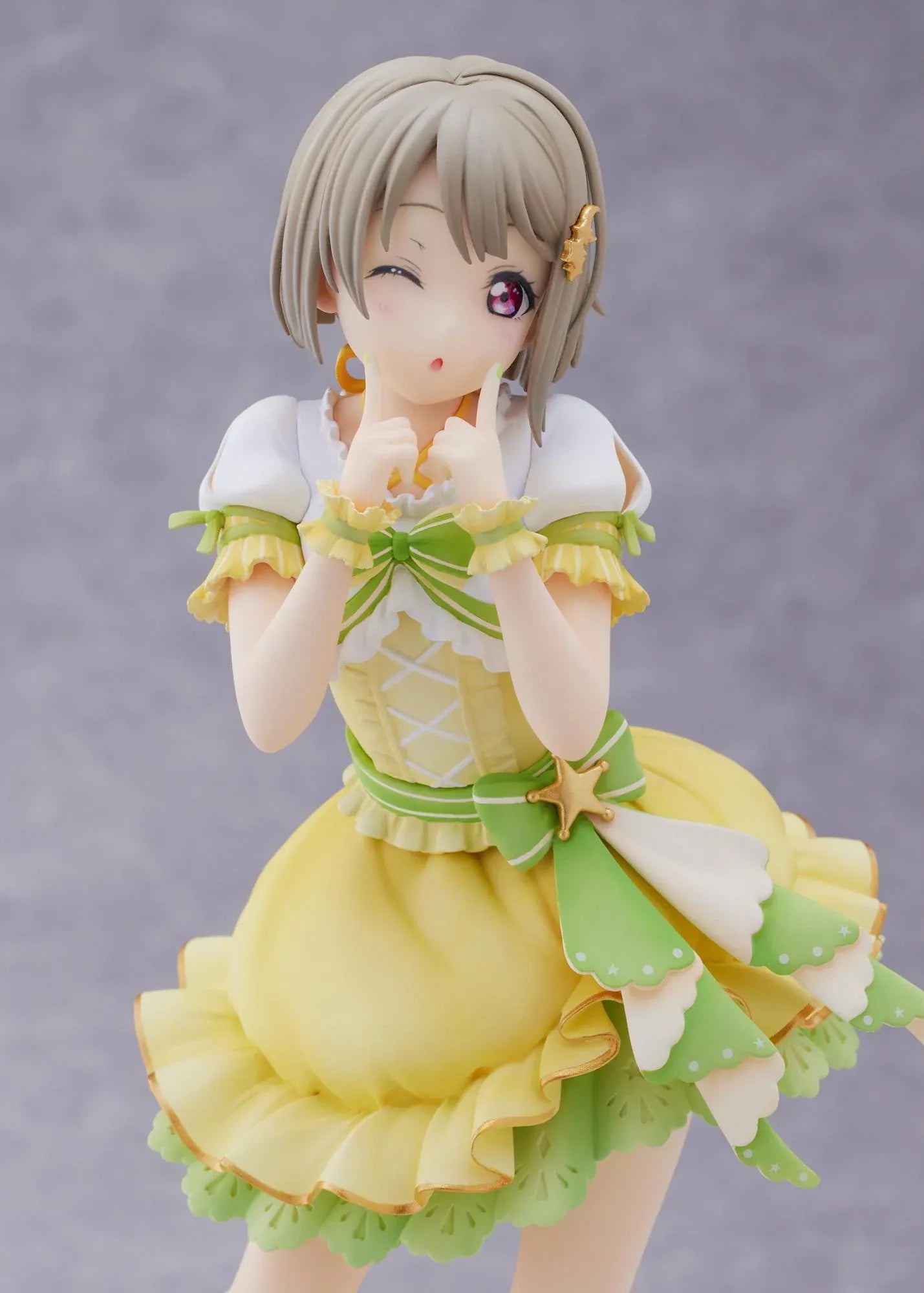 Love Live Nijigasaki High School Idol Club Kasumi Nakasu 1/7 Scale Figure featuring Kasumi in a yellow and green idol outfit with a winking expression, ribbon accents, and matching boots.