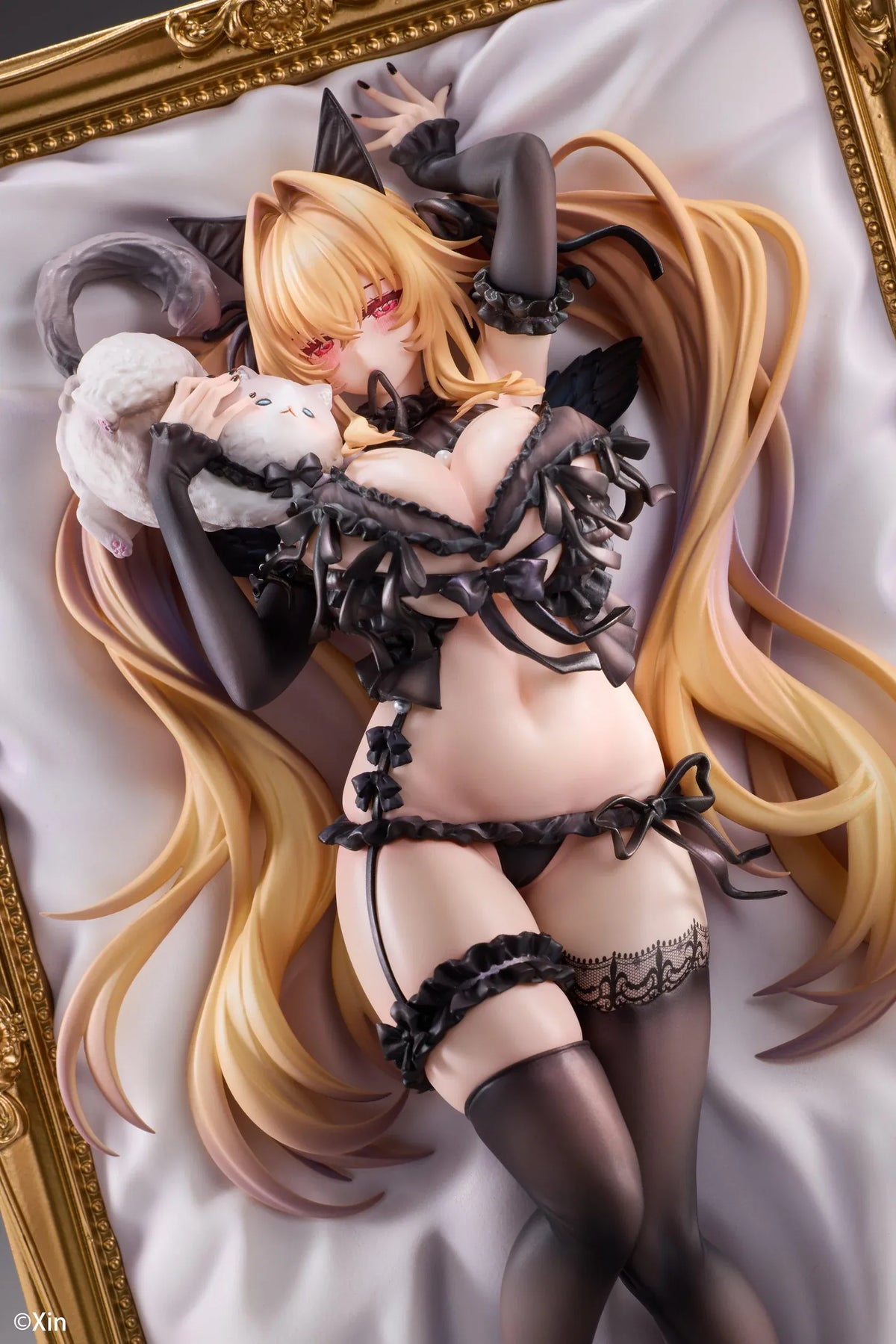 Stella Black Cat Ver. Deluxe Edition 1/7 Scale Figure illustrated by Xin, featuring a blonde-haired catgirl with red eyes, black lace lingerie, cat ears, and thigh-high stockings displayed in an ornate golden frame with a matching illustrated wall scroll.
