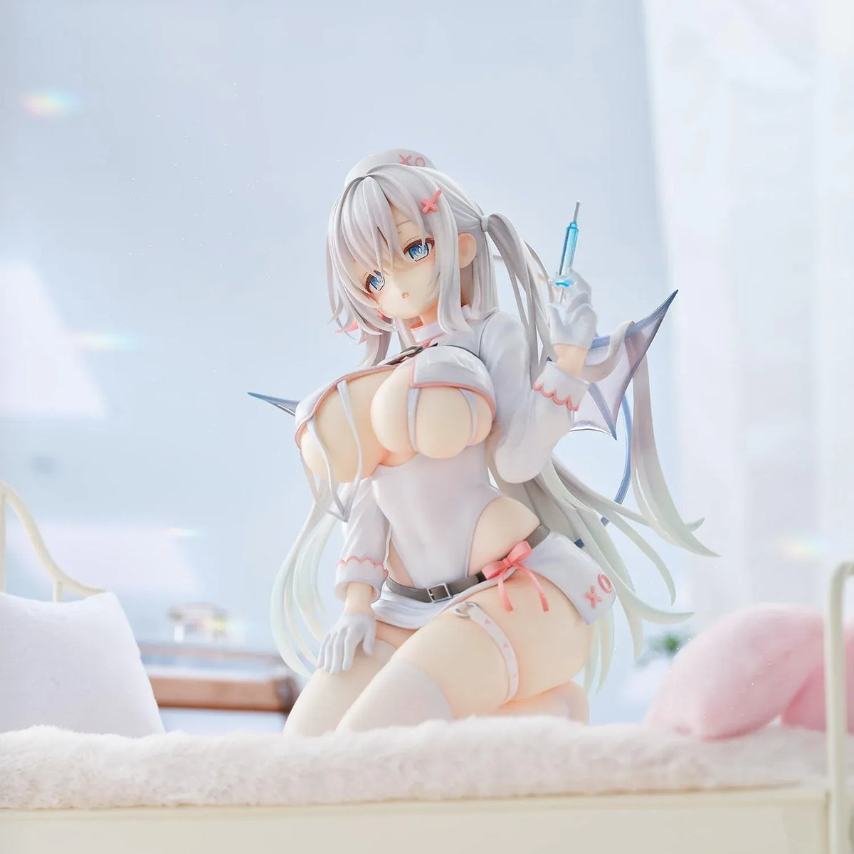 Succubus Nurse Makina figure kneeling in a white and pink nurse outfit with silver hair, batlike wings, a demon tail, and a translucent syringe.
