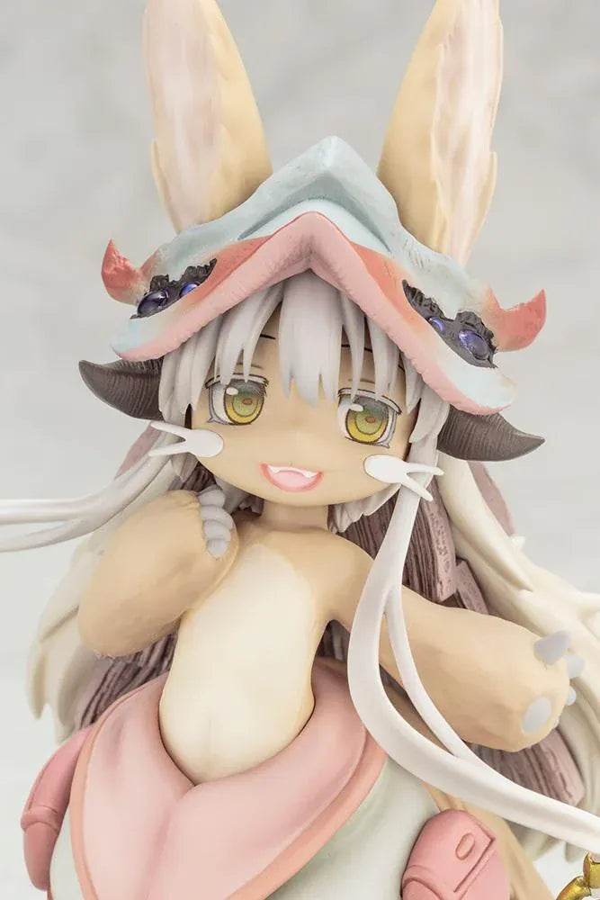 Made in Abyss The Awakening Mystery Nanachi Figure (Rerelease) featuring a fluffy rabbit-like character with long cream-colored ears, golden eyes, an oversized explorer hat, pink and beige clothing, and long flowing hair standing on a detailed scenic base with green moss, rocks, and blue water.