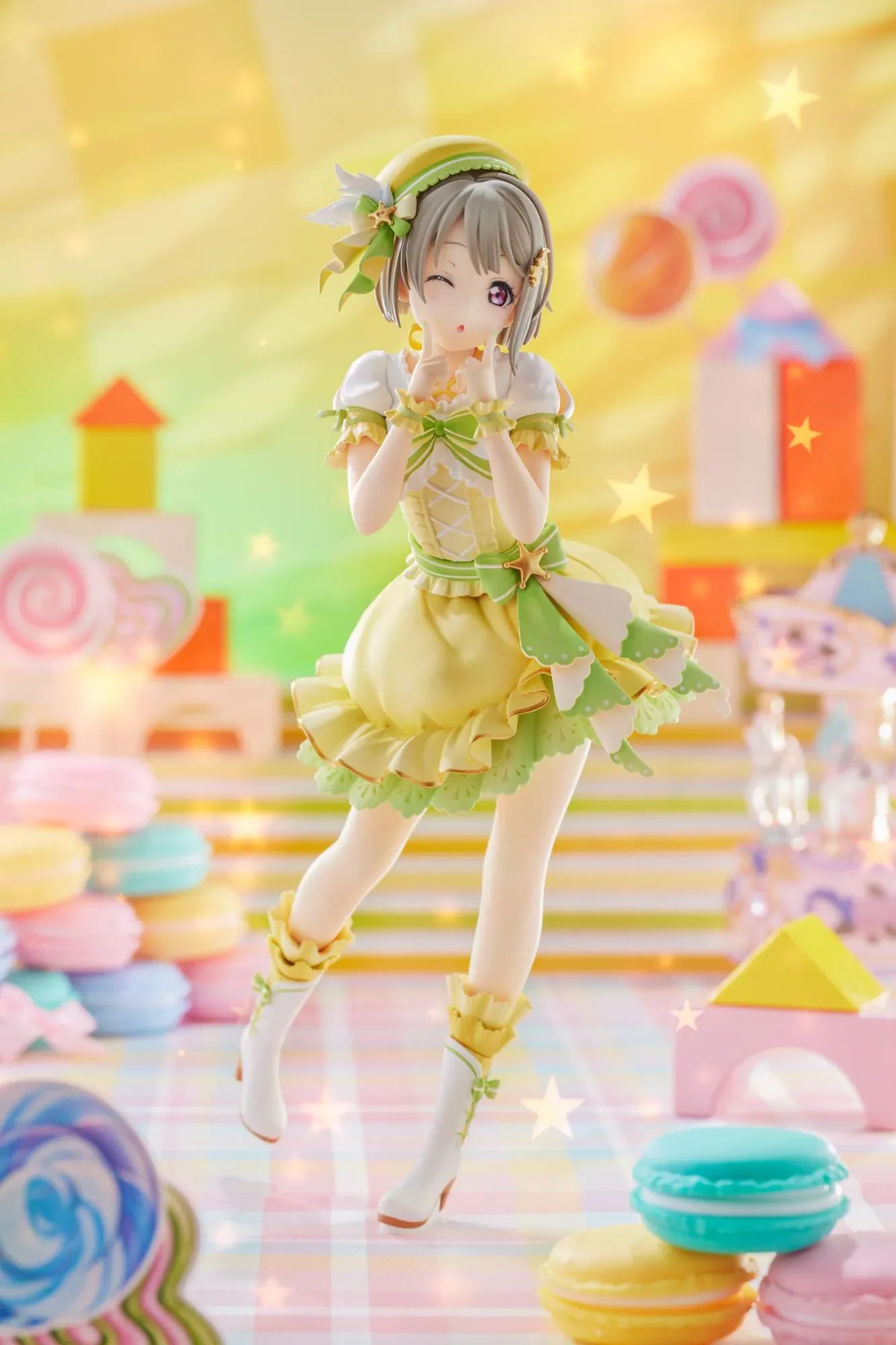 Love Live Nijigasaki High School Idol Club Kasumi Nakasu 1/7 Scale Figure featuring Kasumi in a yellow and green idol outfit with a winking expression, ribbon accents, and matching boots.