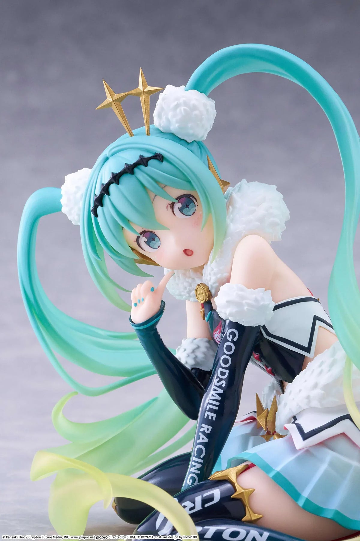 Racing Miku 2018 Ver. Round 8 figure seated in a white, black, and turquoise racing outfit with long gradient twin tails.