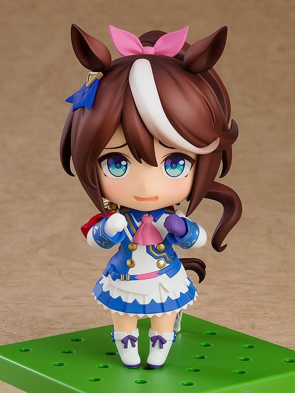 Umamusume Pretty Derby Nendoroid Tokai Teio rerelease figure with brown hair, a white forelock, pink bow, and blue-and-white racing uniform.