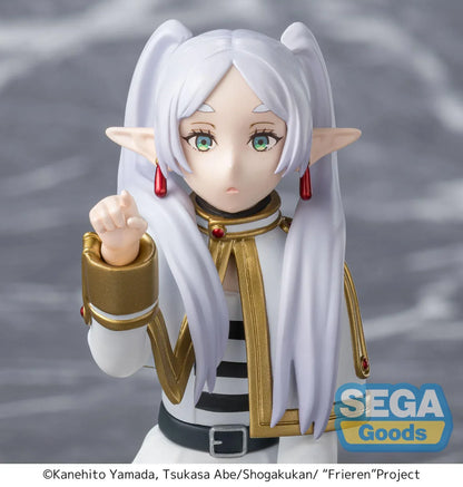 Perching figure of Frieren from Frieren: Beyond Journey’s End kneeling on a stone-like base, reaching forward to poke something, with long silver hair, elf ears, and a white-and-gold outfit.