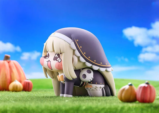 Petite Speaki soft vinyl figure with blonde hair, rosy cheeks, sparkling eyes, and a dark hood with gold accents.