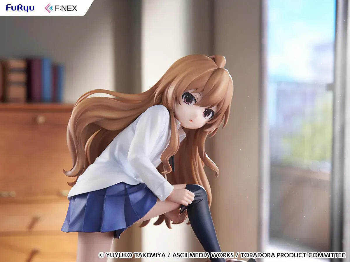 1/7 scale Toradora figure of Taiga Aisaka at home, barefoot and leaning on a leather armchair while pulling on a black thigh-high sock, wearing her school shirt and blue skirt.