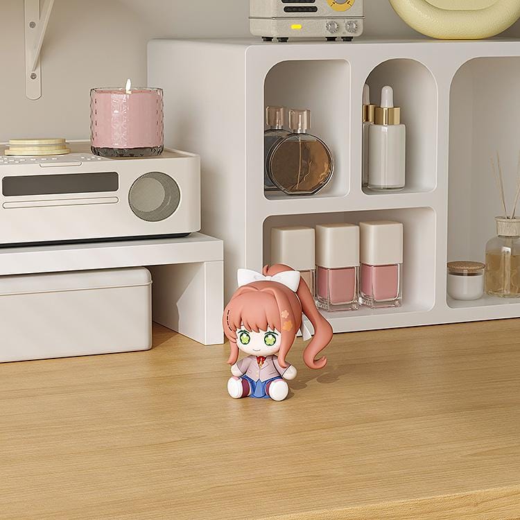 Doki Doki Literature Club! Huggy Good Smile Monika figure with green flower-filled eyes, a white hair bow, and a school uniform in a seated pose.