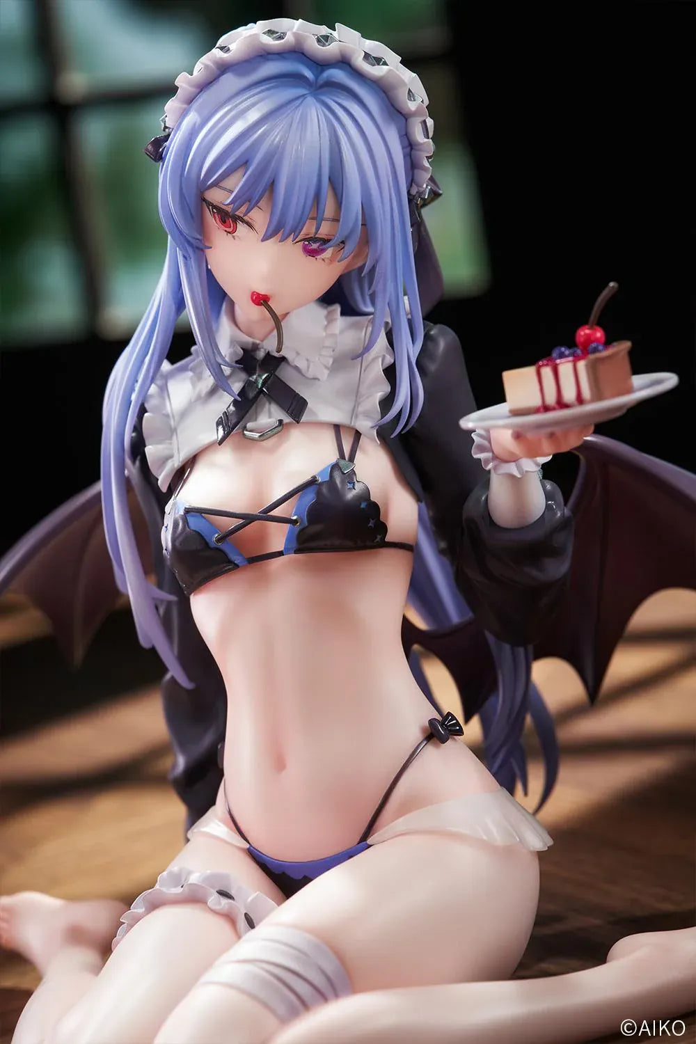 NIYA Maid Ver. figure illustrated by AIKO, with blue hair, a frilled headband, dark wings, and a dessert plate, seated on a wood-patterned base.