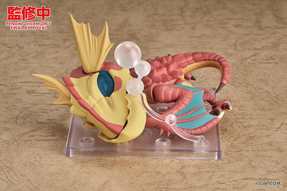 Monster Hunter Nendoroid Yian Kut-Ku with yellow ear fans, an open beak, pink-red scales, and spread wings with turquoise membranes.